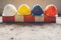 Safety helmet, white, yellow, blue and orange, placed on the cement floor in the construction site Royalty Free Stock Photo