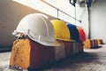 Safety helmet, white, yellow, blue and orange, placed on the cement floor in the construction site