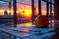 Safety helmet and work tools with sunset and construction site in the background Royalty Free Stock Photo