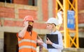 Safety inspector concept. Inspector and bearded brutal builder discuss construction progress. Construction project Royalty Free Stock Photo