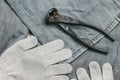 Safety knitted Work Gloves for industrial use and very aged and rusty pliers against the background of the old, rough