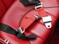 Safety lap belts on red leather car seat Royalty Free Stock Photo