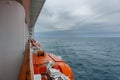 Safety lifeboat on deck of a cruise ship. Bad weather condition. Royalty Free Stock Photo