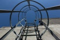 Safety metal ladder to the roof and blue sky, iron staircase