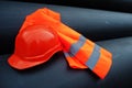 Safety orange worker helmet at steel pipes. Royalty Free Stock Photo