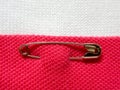 Safety pin on fabric background with note space