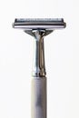 A safety razor with a metallic handle and blade, isolated on a white background Royalty Free Stock Photo