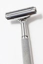 A safety razor with a metallic handle and blade, isolated on a white background Royalty Free Stock Photo