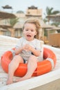 Safety, rescue and help concept. Happy child sit in ring buoy on sunny day. Little boy with lifebuoy on tropical beach. Kid with b Royalty Free Stock Photo