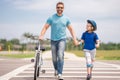 Safety on road. Pedestrian crossing for cyclists. Father teaching son cycling. Father and son learning to ride a bicycle Royalty Free Stock Photo