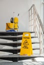 Safety sign with phrase Caution wet floor and mop bucket Royalty Free Stock Photo