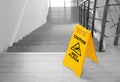 Safety sign with phrase Caution wet floor near stairs Royalty Free Stock Photo