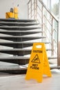 Safety sign with phrase Caution wet floor near stairs Royalty Free Stock Photo