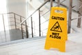 Safety sign with phrase Caution wet floor near stairs Royalty Free Stock Photo