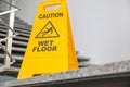 Safety sign with phrase Caution wet floor on stairs Royalty Free Stock Photo