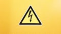 Safety sign yellow and black glued on a yellow wall. High voltage lightning in a triangle caution caution danger electricity death Royalty Free Stock Photo