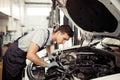 Safety sirst: a good-looking car mechanic is checking the engine Royalty Free Stock Photo