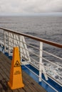 Safety warning marker Teak lined Promenade Deck of modern cruise ship on a grey stormy day Royalty Free Stock Photo