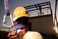 Safety workplace construction worker wearing yellow safety helmet fall arrest PPE harness attached an inertia reel shock absorber Royalty Free Stock Photo