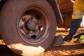 Safety workplaces close up picture of miner track driver wearing safety hand glove placing wheel chock