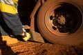 Safety workplaces close up picture of miner track driver wearing safety hand glove placing wheel chock Royalty Free Stock Photo