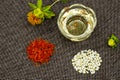 Safflower. Oil, seeds, bud, flower, red inflorescences of wild saffron. Close-up, Gray woven background. Ingredients for health,