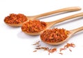 Safflower petals in a spoon on white background