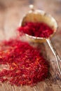 Saffron spice in rustic sieve on old wooden background