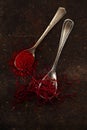 Saffron spice threads and powder in vintage old spoons Royalty Free Stock Photo