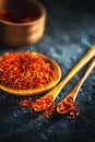 Saffron spices. Saffron on black stone table in a wood bowl and a spoon. Spice and herbs on slate background Royalty Free Stock Photo