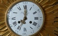 Vintage Berthoud clock face close up with roman numerals hands and brass surround.