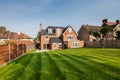 Rear elevation and patio traditional british brick home with lawn