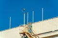 Saftey access ladder on side of building or parking structure in downtown urban city with poles and surveilance camera