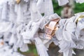 Saga, Japan - Nov. 12, 2018: Japanese random fortune telling paper Omikuji folded and tied on rope wires Omikuji kake in