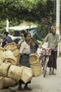 Sagaing/Myanmar-October 3rd 2019: A Burmese elderly wicker vendor carrying baskets made of bamboo in the market