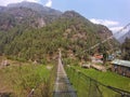 Sagarmatha National Park, Nepal - May 2019: Suspension bridge over the precipice with colorful flags in nepal Royalty Free Stock Photo