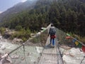 Sagarmatha National Park, Nepal - May 2019: Woman crossing a long bridge in Nepal during the trekking to Everest Base Camp