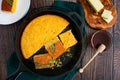 Sage Cornbread Cut Into Pieces in a Cast-Iron Skillet