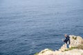 Tourist man gets dangerously close to the edge of the cliff at Cabo Sao Vicente, taking