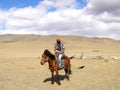 SAGSAY, MONGOLIA - MAY 22, 2012: Mongolian horseman shepherd his of sheep in the desert