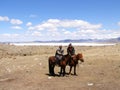 SAGSAY, MONGOLIA - MAY 22, 2012: Mongolian teenagers horsemen shepherd their sheep in the beautiful spring desert