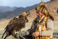 Berkutchi Eagle Hunter while hunting to the hare with a golden eagles on his arms in the mountains of Bayan-Olgii aimag. Royalty Free Stock Photo