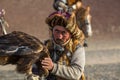 Berkutchi Eagle Hunter while hunting to the hare with a golden eagles on his arms in the mountains of Bayan-Olgii aimag.