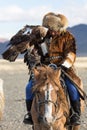 Berkutchi - Eagle Hunters traditional clothing, while hunting to the hare holding a golden eagles on his arms