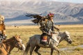 Eagle Hunter teaches her young daughter hunting with birds of prey to the hare in desert mountain of Western Mongolia.