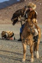 Kazakh woman Eagle Hunter traditional clothing, while hunting to the hare holding a golden eagle on his arm.