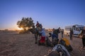 Bedouins preparing trip for tourist mounted on camels to ride off