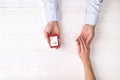 Engagement / marriage / wedding proposal scene. Close up of man handing the expensive gold platinum diamond ring to his bride. Royalty Free Stock Photo