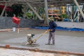 Saigon, Vietnam - 18 July, 2019: Worker makes concrete pour. Asphalt renovation street work. Park road paving process Royalty Free Stock Photo