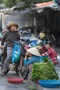 Saigon, Vietnam - June 2017: Woman on motorbike shopping vegetable on farmer market, Saigon, Vietnam.